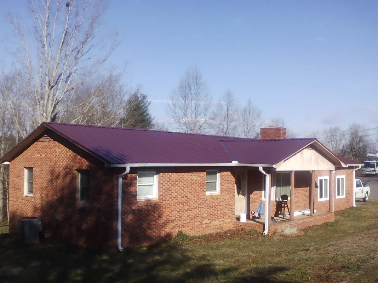 Burgundy metal roof on a brick ranch home with a new addition in Camden